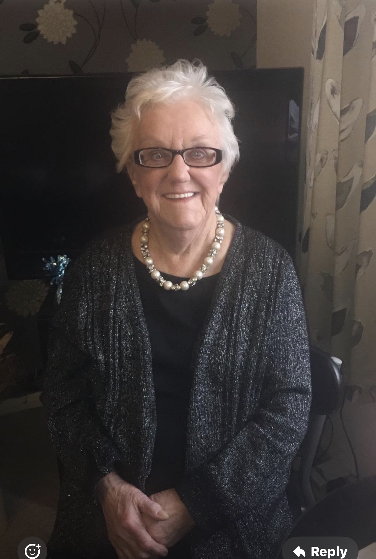 Original family photograph of Violet, smiling with short white hair and dark glasses